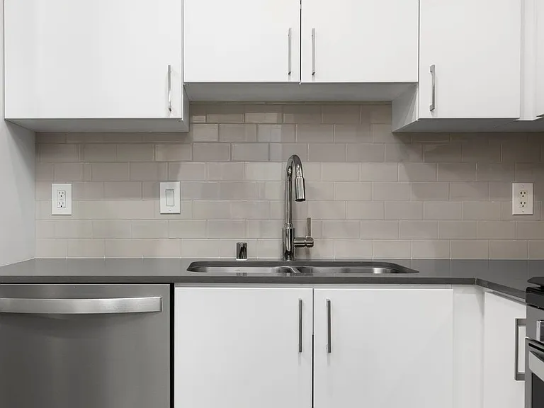 Renovated Package I kitchen with quartz countertops, white cabinetry, stainless steel appliances, hard surface vinyl plank flooring, and tile backsplash