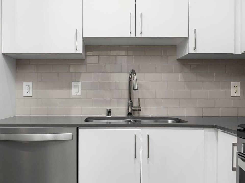 Renovated Package I kitchen with quartz countertops, white cabinetry, stainless steel appliances, hard surface vinyl plank flooring, and tile backsplash