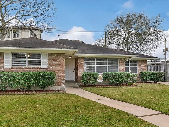Front elevation of the home, with 3 big windows leading to the main room by the entry door and study on the right.  Enjoy a detached garage with a long driveway. Drive by this street and you will notice how many million dollar plus homes already there.