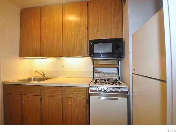 Kitchen has a plenty of cabinets for storage and appliances included a range, microwave and refriger