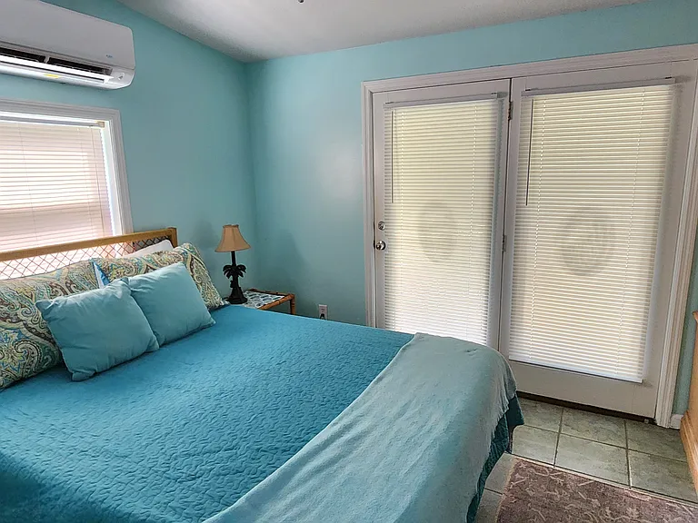 Queen sized bed with lanai doors at bedroom