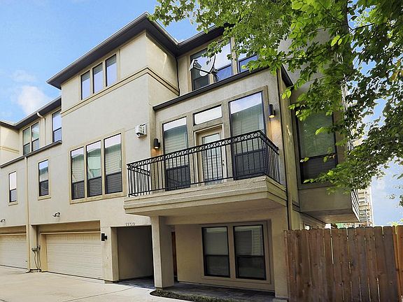 Side view of lovely home featuring 2 car garage and balcony.