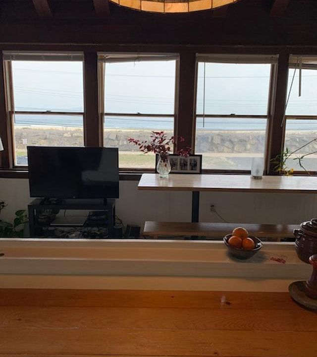 Photo taken on a misty day but you can see the sea wall and the ocean through the window.