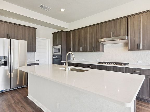 The kitchen features slate-colored cabinets and quartz countertops.