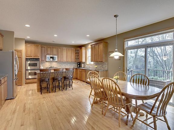 Kitchen dining leads to the deck and separates kitchen and family room. Gorgeous maple floors.