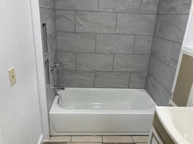 Tub/shower in master bedroom private bathroom. Tile flooring.