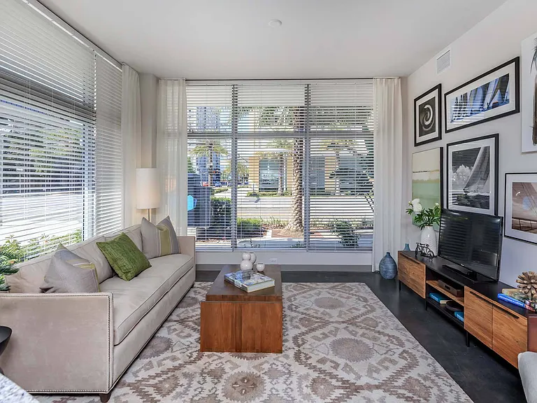Relax in a living room where large windows fill the space with light, creating a bright and inviting atmosphere.