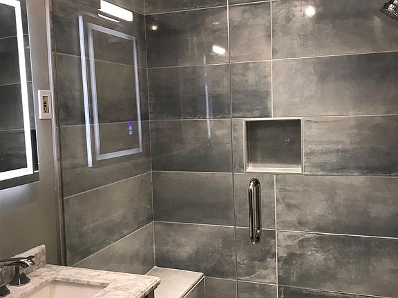 Spa-inspired frameless shower, bench & LED vanity