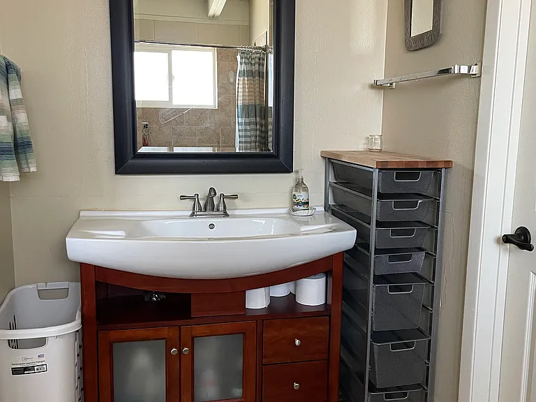 Jack and Jill style Bathroom: Full tub with shower, toilet, sink, and storage space for cosmetics.