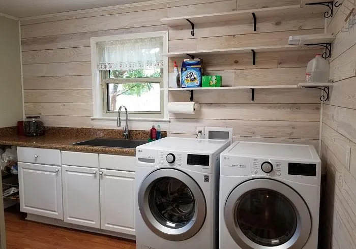 The laundry room is through the door by the kitchen. It has a doorway to the garage on the right and doorway to the outside deck on the left.