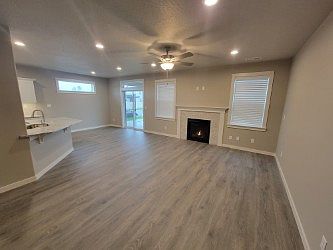 Open living room with fireplace. LVP flooring. Nice and room living room that exits out into the backyard.