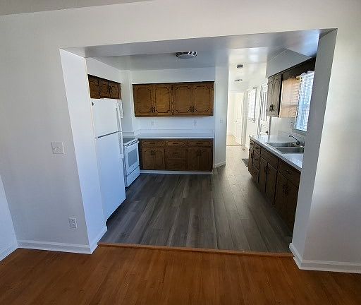 Kitchen looking from Dining Room. Past Kitchen on left is Half Bath/Laundry, Door at end of Hall is a Bedroom
