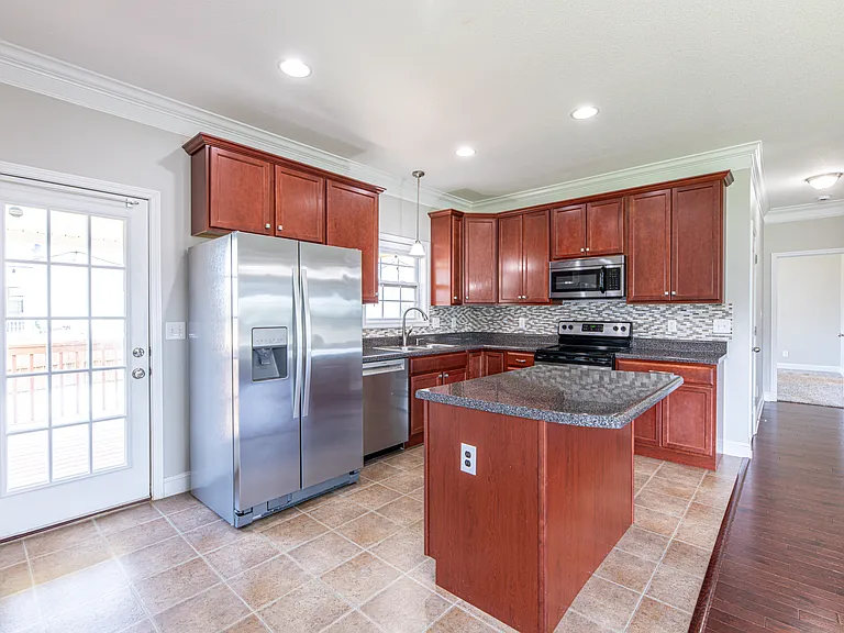 All stainless steel appliances, with touch free sink faucet and stone backsplash