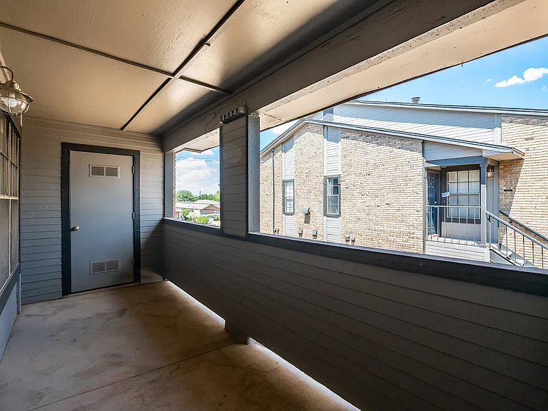 A large covered patio is shown with doors leading inside the apartment and a door leading to the mechanical room.
