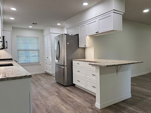 Kitchen bar area open to living room; stainless appliances; lots of storage; custom cabinets with built-ins