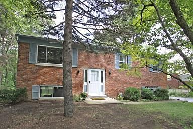 Large brick home with mature landscaping.