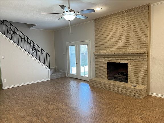 Spacious living area featuring a brick fireplace, wood-look easy care ceramic tile flooring.