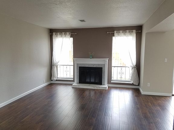 Living room open to dining & kitchen with wood burning firep