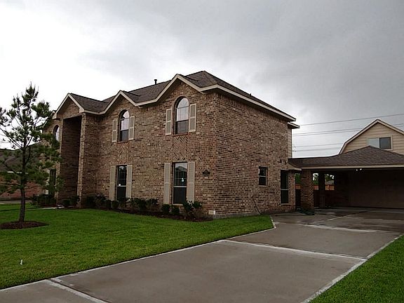 This view shows the huge 2 car garage with porte cochere and room above.