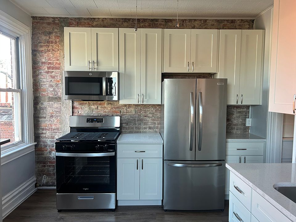 New solid wood cabinets with quartz countertops, exposed brick wall