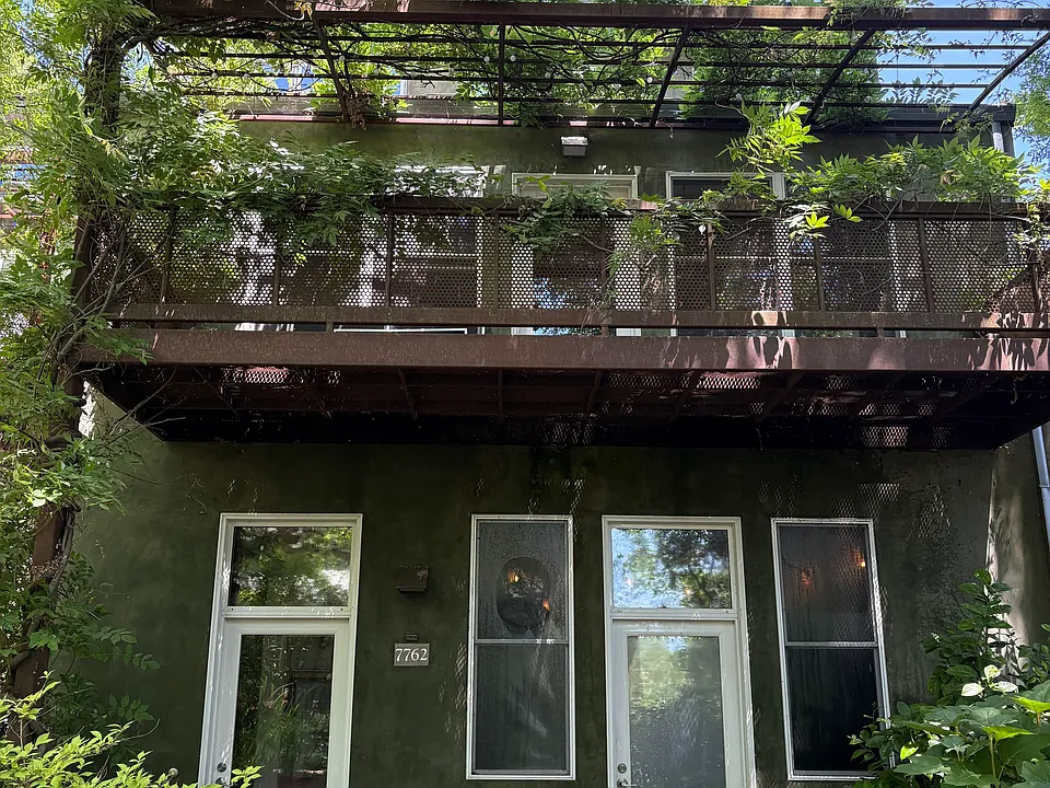 Picture of front of home. Left door takes you upstairs to the 2nd and 3rd floors of this rental, with balcony