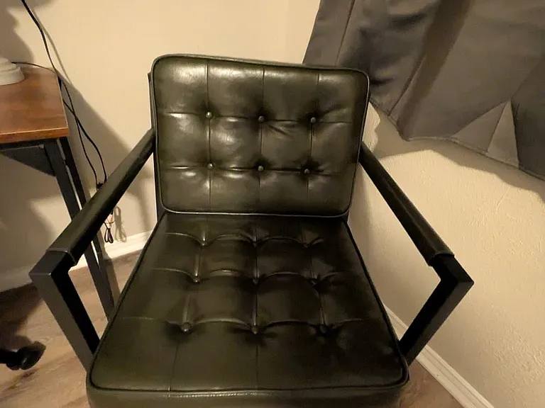 Small seating nook with a cushioned accent chair, side table space, and easy-care flooring for daily use.