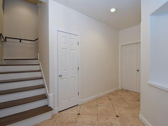 Entryway with coat closet and art niche. 1st floor bedroom is behind the double door.