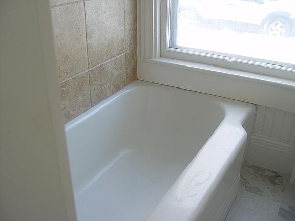 Original Bath Tub with tile surround. This picture was taken before we put up the privacy shade. The windows in this unit are 79 inches tall.