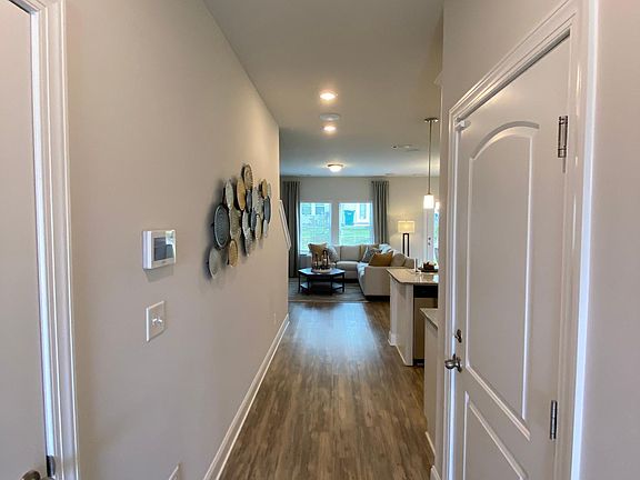 Entryway with half bath to the left and garage door on the right. Staged unit - does not come furnished.