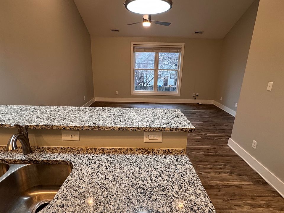 Open concept kitchen and living space area with vaulted ceiling.