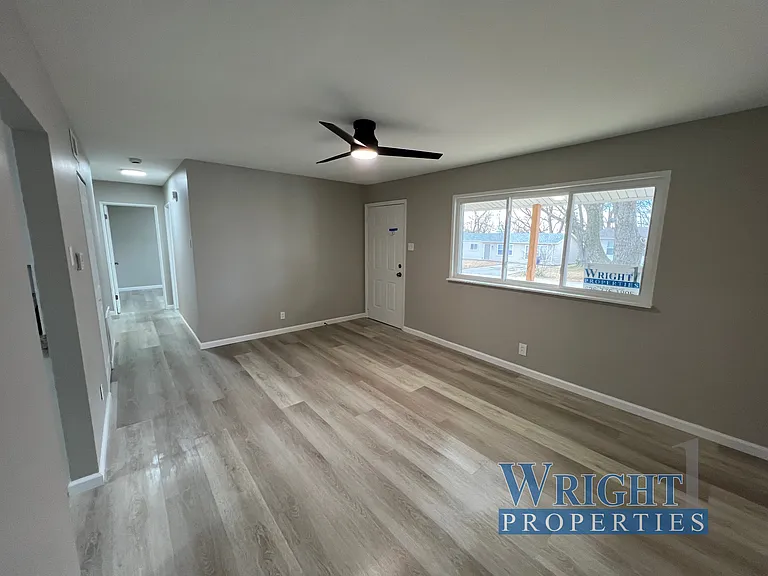 Living room/ Front entrance with large front window to the right and Hallway to the left, which leads to 3 more bedrooms and full bath.