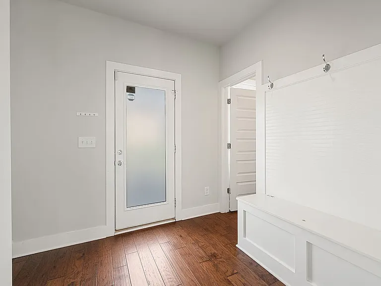 Rear entrance, half bath, and cubby storage.