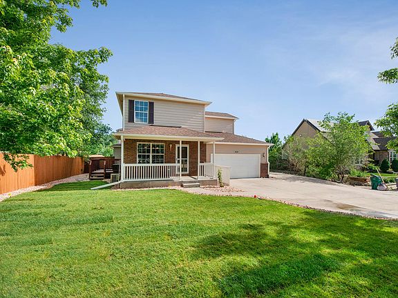 View of side deck as well as front porch and parking. Sprinkler system in place for the lawn.