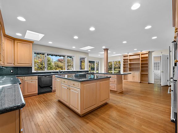 Chef's kitchen featuring skylights, granite counters, double ovens, and a large island for entertaining.