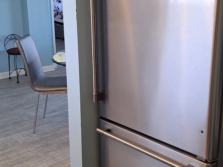 Maytag bottom freezer and top refrigerator with storage cabinet above.