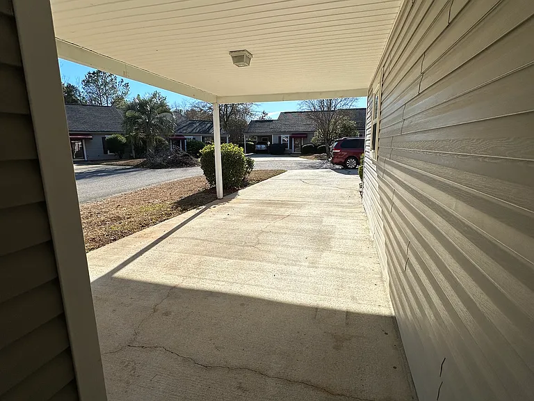 covered carport fits 1 vehicle while uncovered cement pad fits 2 additional vehicles
