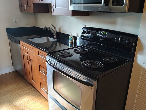 Modern kitchen with granite countertops, gas stove, and stainless steel appliances.