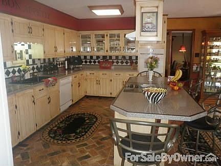 Large country kitchen w/center island. Loads of cabinet space. split brick floor