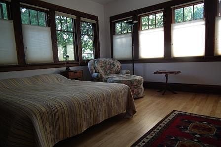 upstairs master bedroom, 3 walls of windows look out on tree