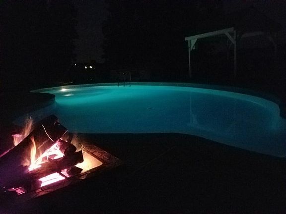 Pool with lighting and fire pit at night