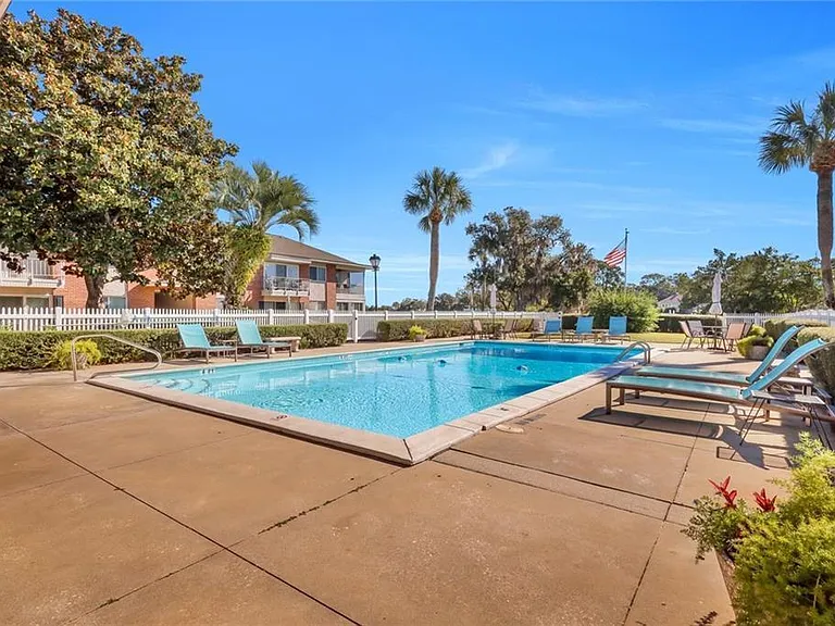 Community pool overlooks the golf course. Tables, lounge chairs , umbrellas and men's and women's rest rooms for your convenience