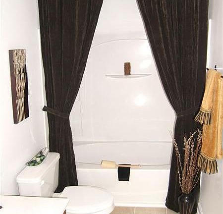 One of two full bathrooms has tile flooring, beautiful cabinetry & shower/tub