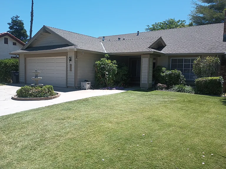 Front of home, two car driveway, automatic sprinklers