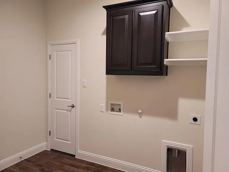 Large utility room with W/D hookup, cabinet and shelves.