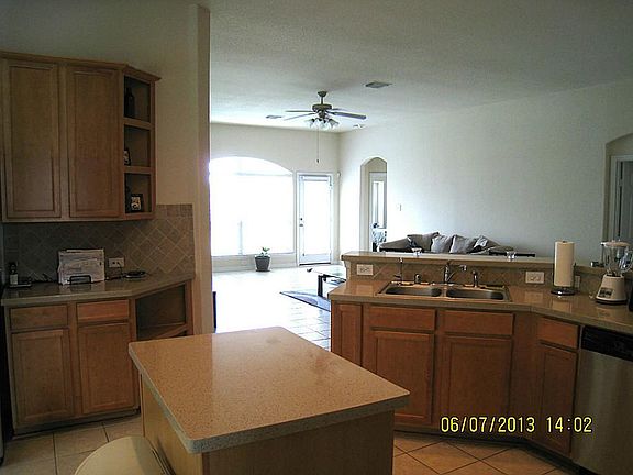 Island kitchen with plenty of cabinets and sit down bar open to family room