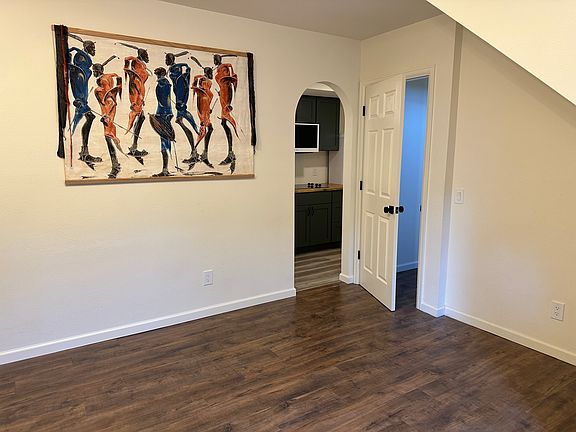 Living area. Archway goes to kitchenette, door leads directly to garage door