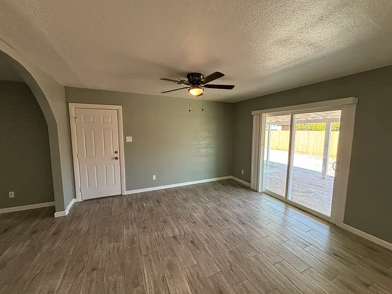 Large kitchen with sliding glass door to spacious backyard.