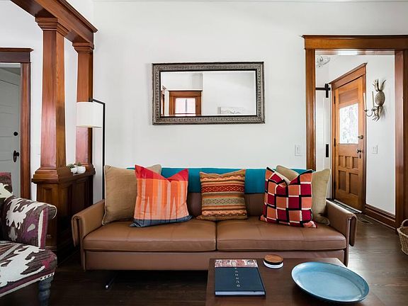 Living room with view to front door and entry closet (see barn door)