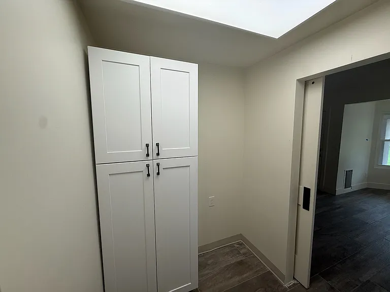 Laundry room has custom cabinets and the space next to them is wired for a second refrigerator. Laundry room door opens across from breakfast nook.