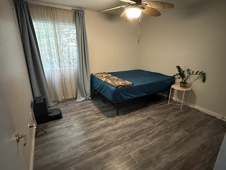 Guest bedroom with window face courtyard. Room includes a wall closet and ceiling fan.